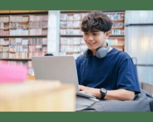 Teen student studying online on a laptop in a modern library